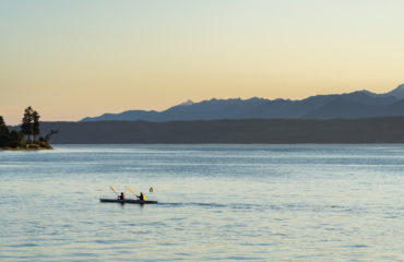 Couple kayaking in the Hood canal with Olympic National Park in