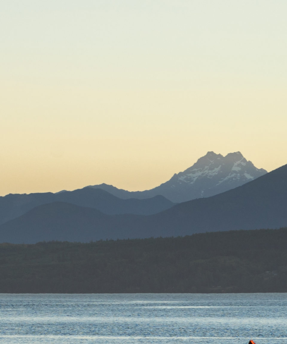 Couple kayaking in the Hood canal with Olympic National Park in